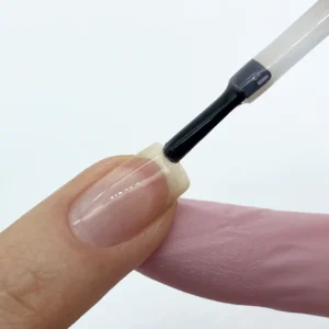 Aplicando Base Coat a una uña para un esmaltado permanente
